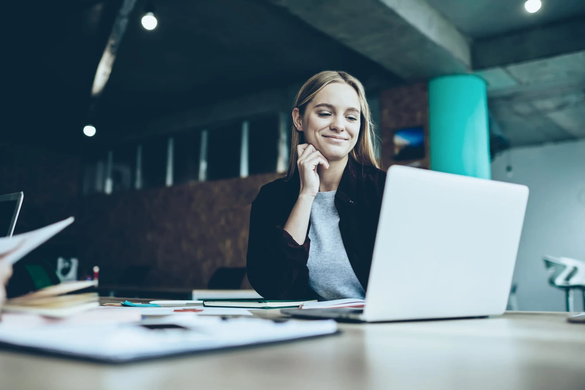 A woman working at a laptop, from Care Pension & Forsikring’s website.